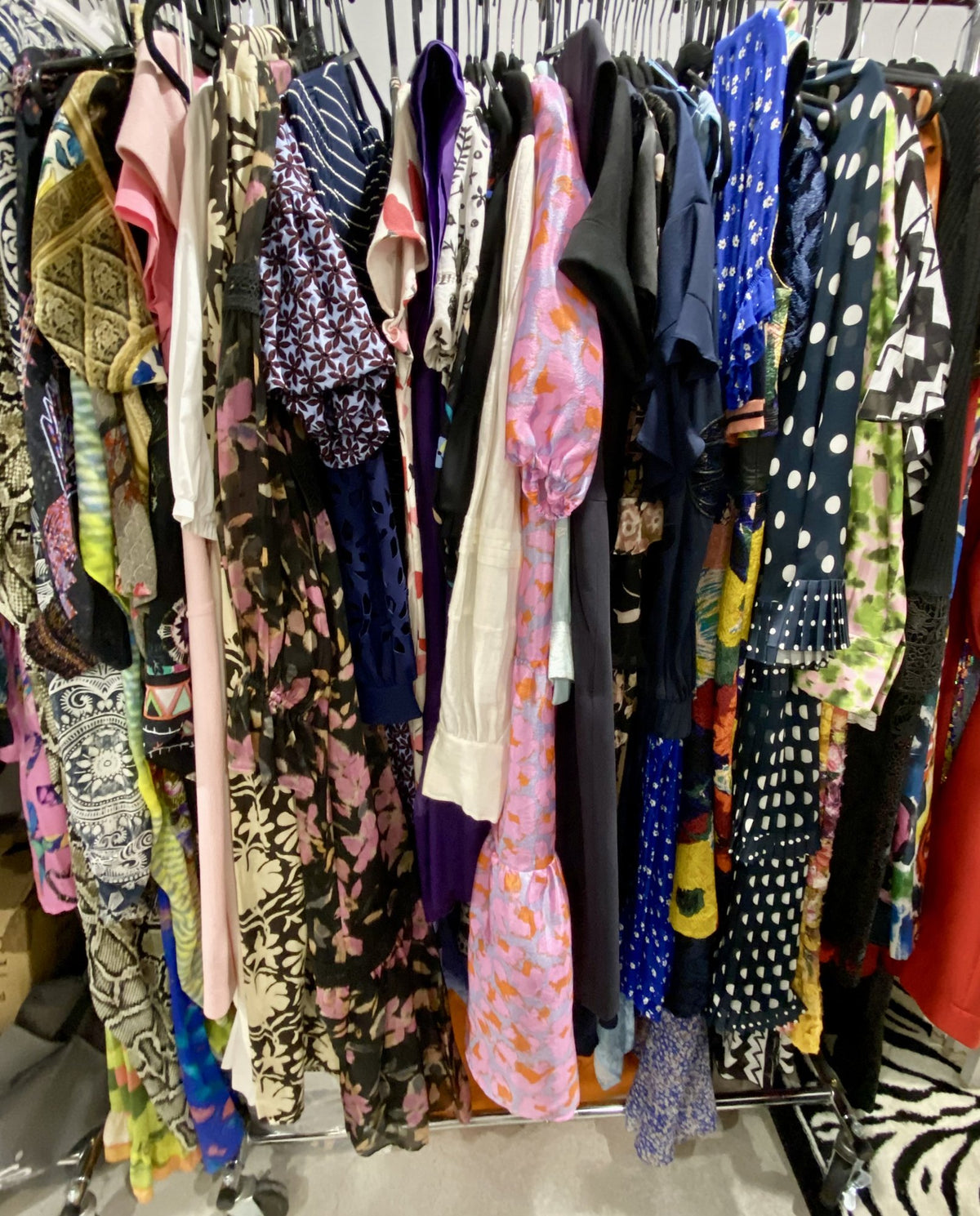 Colourful designer dresses and blouses on the rail at Secondo