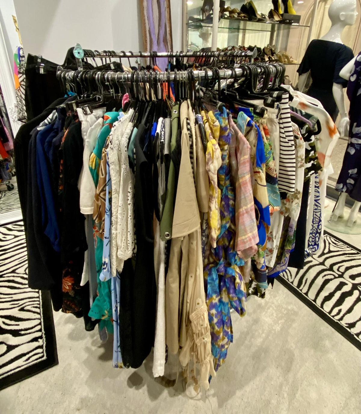 A round rail of designer pieces on a zebra print rug at Secondo